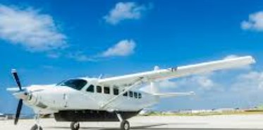White Cessna Grand Caravan 208B on the ramp under a blue sky